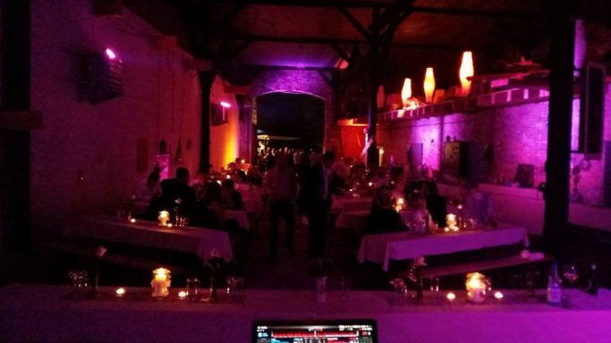 Gemütliches Restaurant mit Kerzenlicht und bunten Lichtern, voll von Gästen.