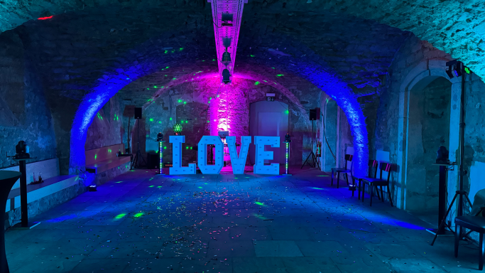 Futuristische Eventlocation mit bunten Lichtern und einem großen "LOVE"-Schild.