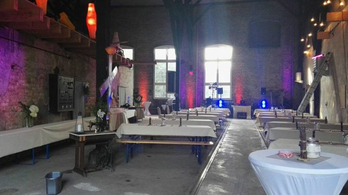 Ein stilvoll dekorierter Veranstaltungsraum mit Tischen und sanfter Beleuchtung.